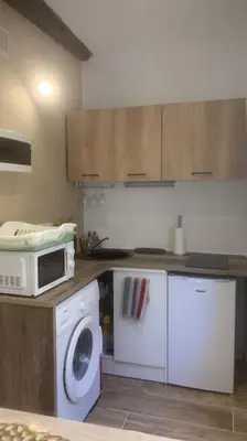 a kitchen with a washing machine and a microwave at Grands Buffets hébergement Studio Narbonne in Narbonne