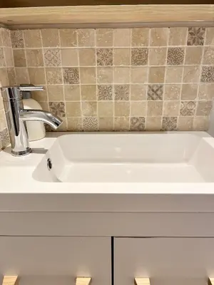 a white sink in a bathroom with a tile wall at Studio centre historique RDC - WIFI in Revel