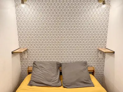a bedroom with a bed and a wall with a pattern at Studio centre historique RDC - WIFI in Revel