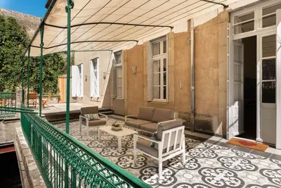 a patio with a couch and a table on a balcony at Appartement chic, hôtel particulier, Carcassonne centre in Carcassonne