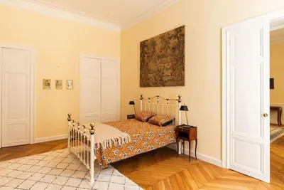 a bedroom with a bed and a painting on the wall at Appartement chic, hôtel particulier, Carcassonne centre in Carcassonne