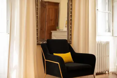 a black chair with a yellow pillow in a room at Appartement chic, hôtel particulier, Carcassonne centre in Carcassonne