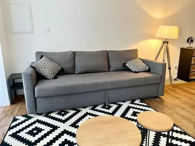 a living room with a gray couch and a rug at Appartement Victor Hugo - balcon in Revel