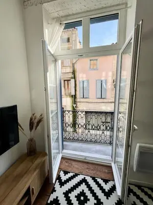 a room with a large window with a view of a building at Appartement Victor Hugo - balcon in Revel