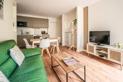 a living room with a green couch and a table at Chaleureux appartement, centre ville in Narbonne
