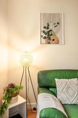 a green couch in a living room with a lamp at Chaleureux appartement, centre ville in Narbonne
