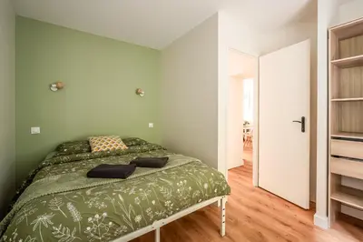 a bedroom with a bed in a green wall at Chaleureux appartement, centre ville in Narbonne