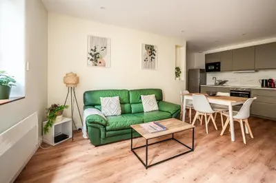 a living room with a green couch and a table at Chaleureux appartement, centre ville in Narbonne
