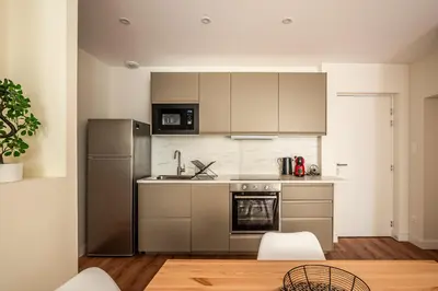 a kitchen with stainless steel appliances and white cabinets at Chaleureux appartement, centre ville in Narbonne