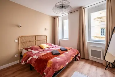 a bedroom with a bed and a large window at Chaleureux appartement, centre ville in Narbonne