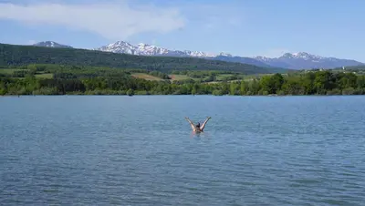 a person standing in a lake with their arms in the air at River House in medieval bastide - Sleeps up to 6 in Chalabre
