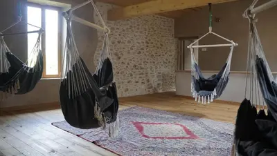 two hammocks hanging in a room with a rug at River House in medieval bastide - Sleeps up to 6 in Chalabre