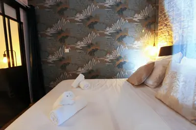 a bedroom with a bed with towels on it at La Demeure du Chevalier d'Argent- parking gratuit in Carcassonne