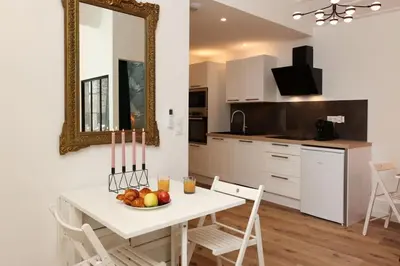 a kitchen with a table with a bowl of fruit on it at La Demeure du Chevalier d'Argent- parking gratuit in Carcassonne