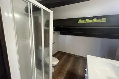 a bathroom with a toilet and a glass shower at Spacious apartment with lovely terrace in Port-la-Nouvelle