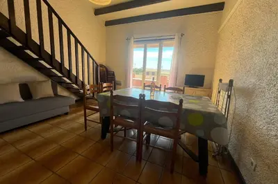a dining room with a table and some chairs at Spacious apartment with lovely terrace in Port-la-Nouvelle