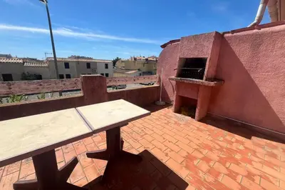 a picnic table on the roof of a building at Spacious apartment with lovely terrace in Port-la-Nouvelle