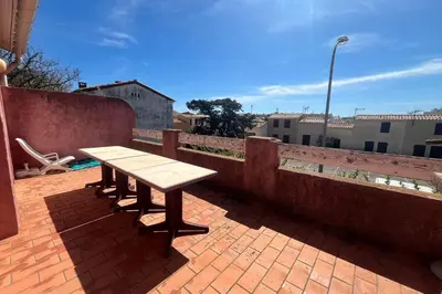 a wooden picnic table on a brick patio at Spacious apartment with lovely terrace in Port-la-Nouvelle