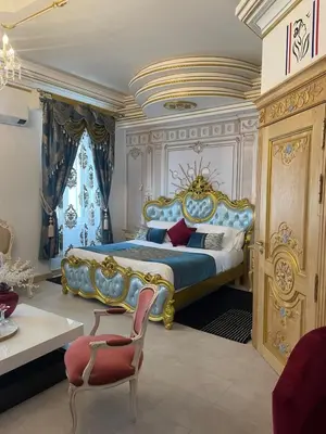 a bedroom with a king sized bed and a chair at Suite Présidentielle Maison de L'Église in Narbonne