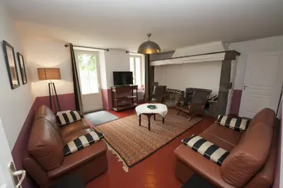 a living room with two leather couches and a table at Château Ciceron in Ribaute