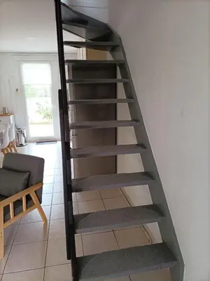 a metal spiral staircase in a living room at Fleur De Sel in Gruissan