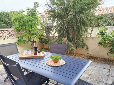 a blue table with a bottle of wine and a plant on it at Fleur De Sel in Gruissan