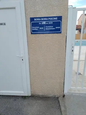 a door with a sign on the side of a building at Fleur De Sel in Gruissan