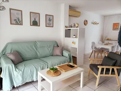 a living room with a green couch and a table at Fleur De Sel in Gruissan