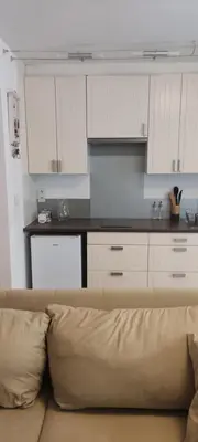 a couch in a living room with a kitchen at Studio centre ville de Narbonne in Narbonne
