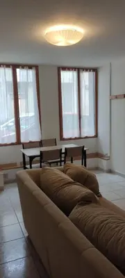a living room with a couch in a room with windows at Studio centre ville de Narbonne in Narbonne