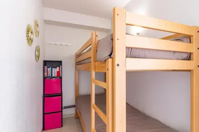 a bunk bed in a room with a ladder at Le Jouarres - Appt climatisé avec piscine partagée in Azille