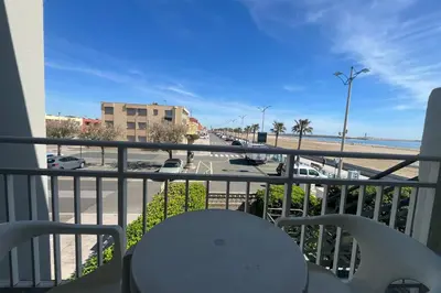 a balcony with a table and a view of the beach at Charming apartment overlooking the sea in Port-la-Nouvelle