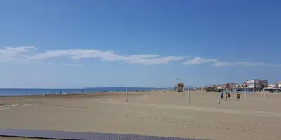 a view of a beach with people walking on it at Charming apartment overlooking the sea in Port-la-Nouvelle