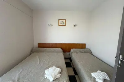 two beds in a small room with towels at Spacious apartment on the seafront in Port-la-Nouvelle