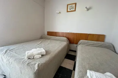 a room with two beds with towels on them at Spacious apartment on the seafront in Port-la-Nouvelle
