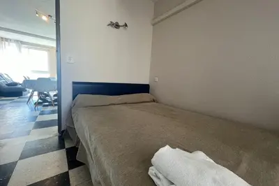 a bedroom with a bed and a room with a table at Spacious 60 m nest with sea view in Port-la-Nouvelle