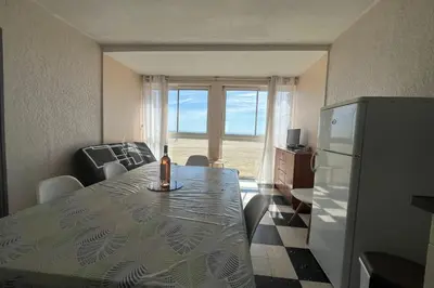 a room with a table with a bottle of wine on it at Spacious 60 m nest with sea view in Port-la-Nouvelle