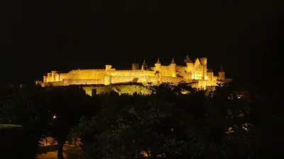 a large castle is lit up at night at Appartement CarcaLuxe in Carcassonne