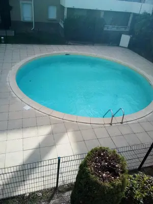 a large pool of water with two chairs in it at Appartement CarcaLuxe in Carcassonne