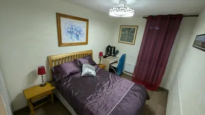 a bedroom with a bed and a table with a lamp at Appartement CarcaLuxe in Carcassonne