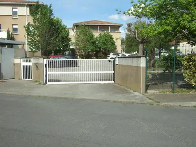 a white gate in front of a house at Appartement CarcaLuxe in Carcassonne