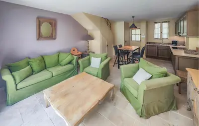 a living room with green couches and a wooden table at Gorgeous Home In Saint-Laurent-De-La-Ca With Wifi in Saint-Laurent-de-la-Cabrerisse