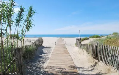 a wooden path to the beach with the ocean in the background at Lovely Home In Saint-Laurent-De-La-Ca in Saint-Laurent-de-la-Cabrerisse