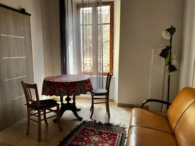 a living room with a table and chairs and a couch at La Résidence Opale in Lagrasse
