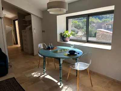 a dining room with a table and chairs and a window at La Résidence Opale in Lagrasse