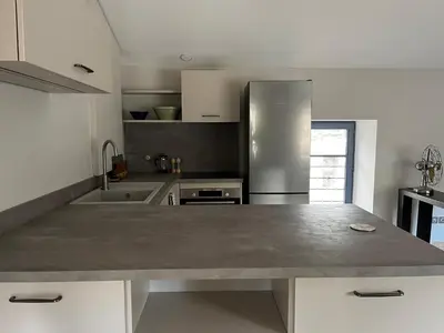 a kitchen with a large counter top in the middle at La Résidence Opale in Lagrasse