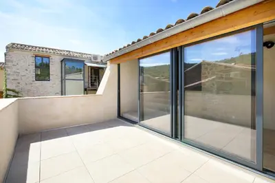 a balcony with sliding glass doors on a house at La Résidence Opale in Lagrasse