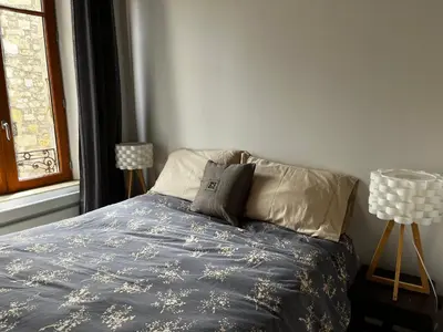 a bedroom with a bed with a blue comforter and two lamps at La Résidence Opale in Lagrasse