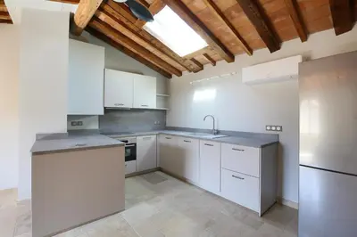 a kitchen with white cabinets and a sink at La Résidence Opale in Lagrasse