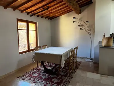 a dining room with a table and chairs and a window at La Résidence Opale in Lagrasse